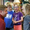 Staff member talks with three children.