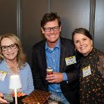 Two women and a man smiling