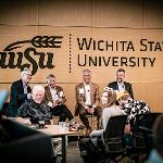 Six people seated around a coffee table