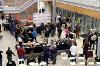 An aerial shot of people talking in groups around a refreshment table.