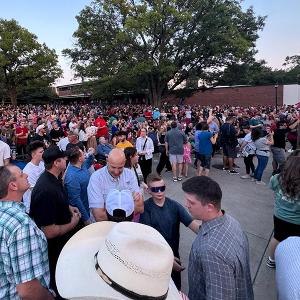 A crowd gathers on the Rhatigan Student Center east lawn for a speakers at a Charlie Kirk vigil in 2025  
