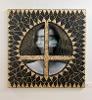A mixed media piece that includes a blurry photo of a woman. The background of the photo is embroidered with gold lines, and the canvas is decorated with gold-painted, burned match sticks. 