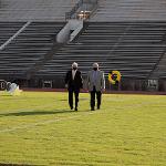 Teammates walk back from placing the wreath at the 50-yard line