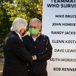 Two crash survivors talk in front of the survivor's monument