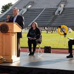 John Yeros speaks at a podium, shot horizontally