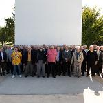 Former team members stand in front of the monument