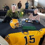 Two attendees seated at a table. A WSU football jersey adorns the table