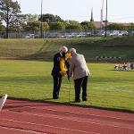 Teammates from the 1970 football team place the wreath at the 50-yard line