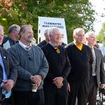 Former team members stand in front of the monument