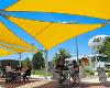 People dine beneath bright yellow sun shades at the WSU Food Truck Plaza