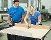 A GoCreate member operates a saw while a another member oversees