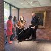 Dean Rodney Miller unveiling the Rigoletto statue. There are a couple people standing to the left of the statue and the Dean is standing to the right with the black cloth that was used to hide the statue. The black cloth is captured as it was moving through the air underneath the statue.