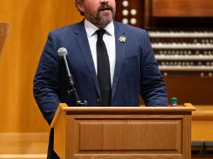 Cody Keenan speaks from the podium at Wiedemann Hall