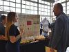 Jessica Gorton presenting to a judge at the Trade Show in front of her team's booth.