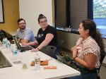 A woman gestures at herself as she explains her product to the others in the training.