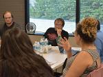 A woman gestures as she makes adds to a group discussion.