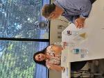 A woman gestures as she gives feedback to the man who just presented his pitch.