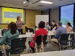 The trainer stands at the front of the group introducing the participants to the training.