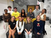 A group of students pose for a photo in the Marcus Welcome Center lobby.