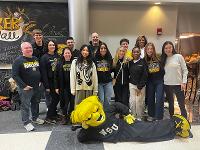 A photo of a group with WuShock laying down on the floor in front.