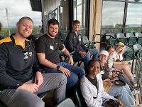 A group of people pose for a photo while seated in the stands of Eck Stadium.