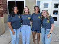 Four Gore Scholars pose in front of the entrance to the Marcus Welcome Center.