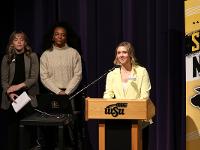 A Gore Scholar stands at a podium on stage to speak.