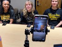 Gore Scholars seated at a table in front of a camera setup to host a live question and answer session.