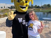 A student poses for a picture with WuShock.