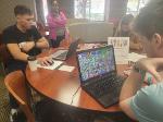 Three competitors seated around a round table compete on Venture Valley.