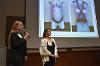 Female Engineering team members stand in front of their slides presenting.