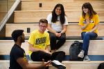 Four students sit and chat on the Woolsey Hall social stair