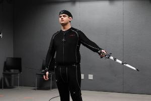 Student posing with a sword in the motion capture studio.