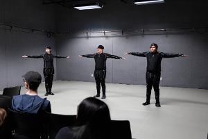 Three people in motion-capture suits doing a t-pose.