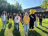 A large group of students pose with Wichita State’s mascot WuShock on a sunny day.