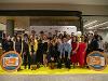 Students and film crew members pose together on a yellow carpet in front of a Wichita State and College Tour backdrop.