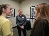 Dr. Monica Lounsbery, senior executive vice president and provost at Wichita State University, smiles while speaking with two students during a campus reception. A laptop and microphone stand are visible in the background.
