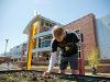 First Gentleman Rick Case leans over a raised garden bed, inspecting new plant growth in Wichita State University's community garden.