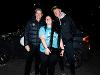 President Rick Muma and First Gentleman Rick Case greet one of the women's bowling student athletes after they returned home from the championship. The photo is at night and the student is holding the team's championship trophy.