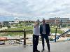 John Tomblin points toward the Wichita State University Innovation Campus while standing beside President Rick Muma inside the under-construction Hub for Advanced Manufacturing and Research.