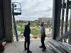 President Rick Muma and John Tomblin stand inside the unfinished Hub for Advanced Manufacturing and Research as Tomblin gestures toward buildings on Wichita State’s Innovation Campus.