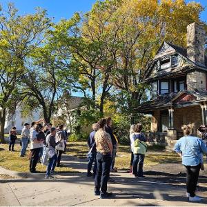 Scarlett Mikler explaining the history of Fairmount  Cottage as part of the fall 2023 adult education walking tour.