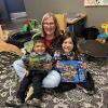 Children with and adult showing their books 