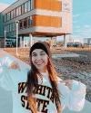 A student shows off their Wichita State sweatshirt in front of Woolsey Hall.