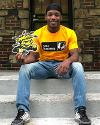 A student wearing a Barton School of Business shirt holds a WuShock cutout.