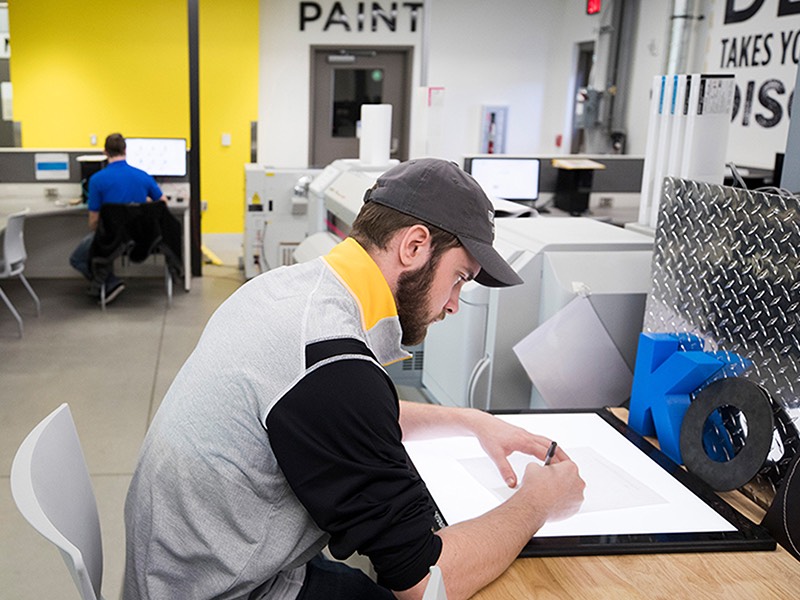 male drawing on a light table