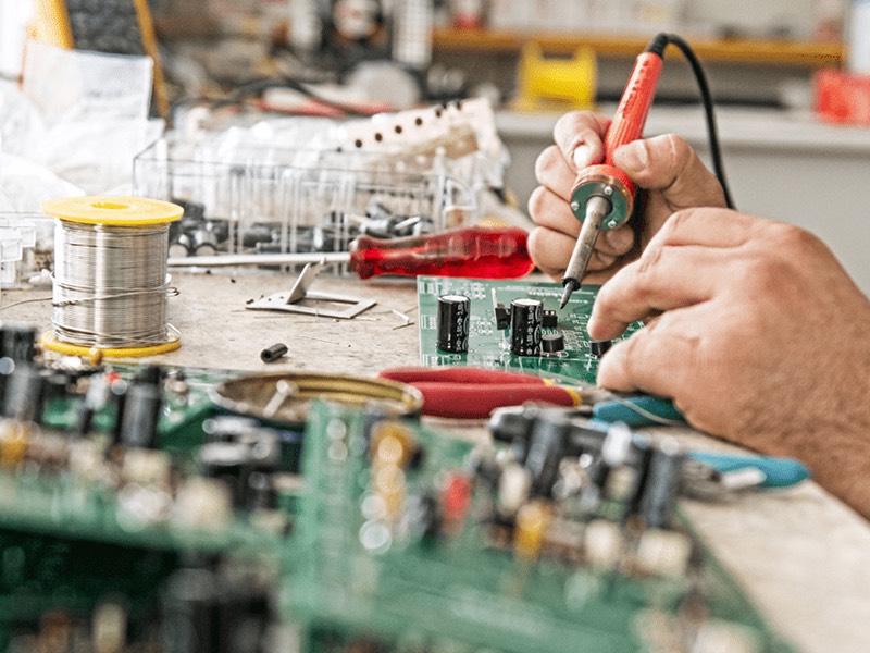 hands working on circuit board
