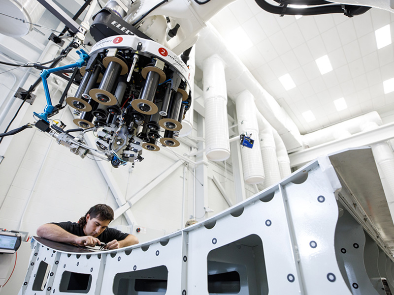 NIAR Employee working in the ATLAS lab with the Electroimpact machine.