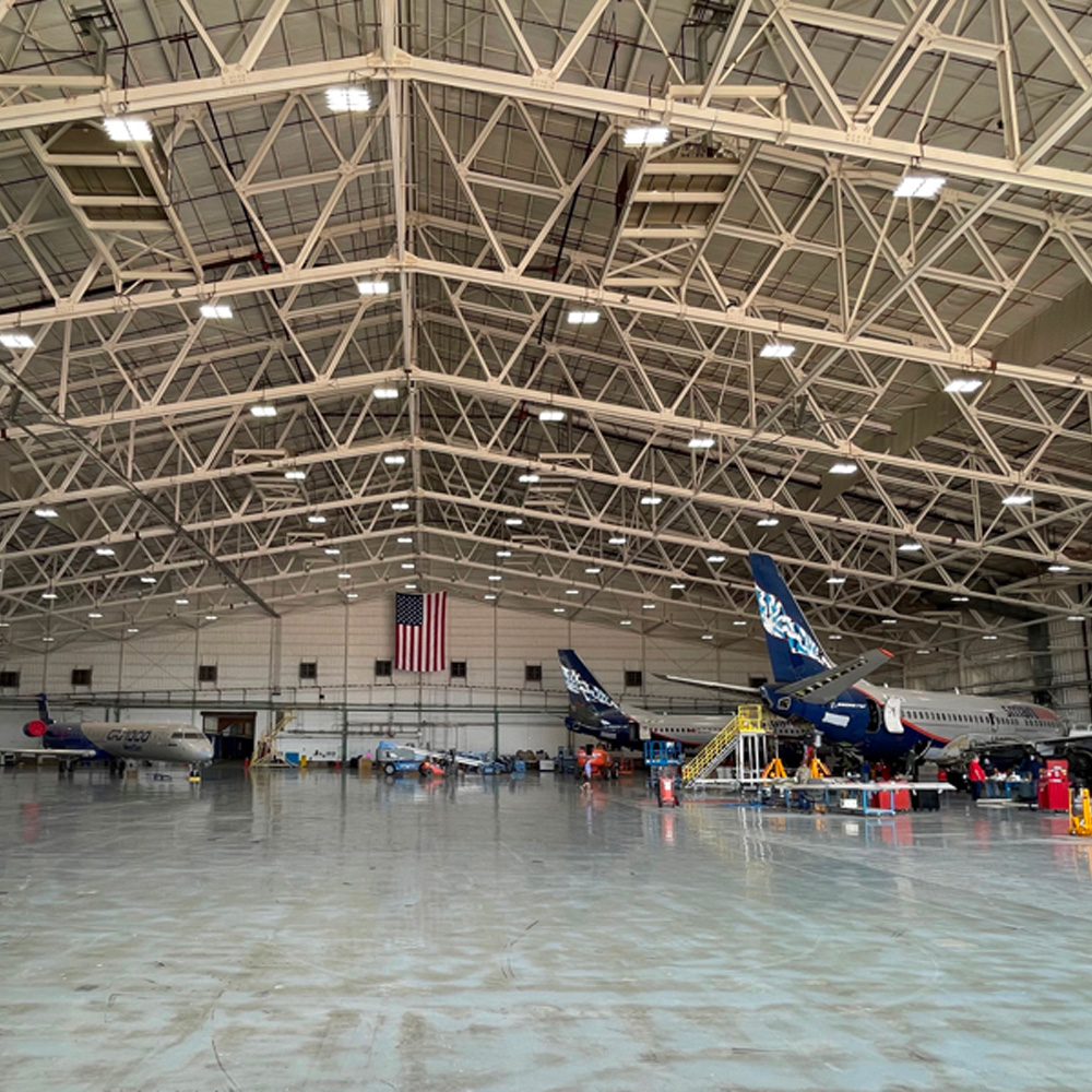 photo of an airplane hangar with different aircraft on the floor