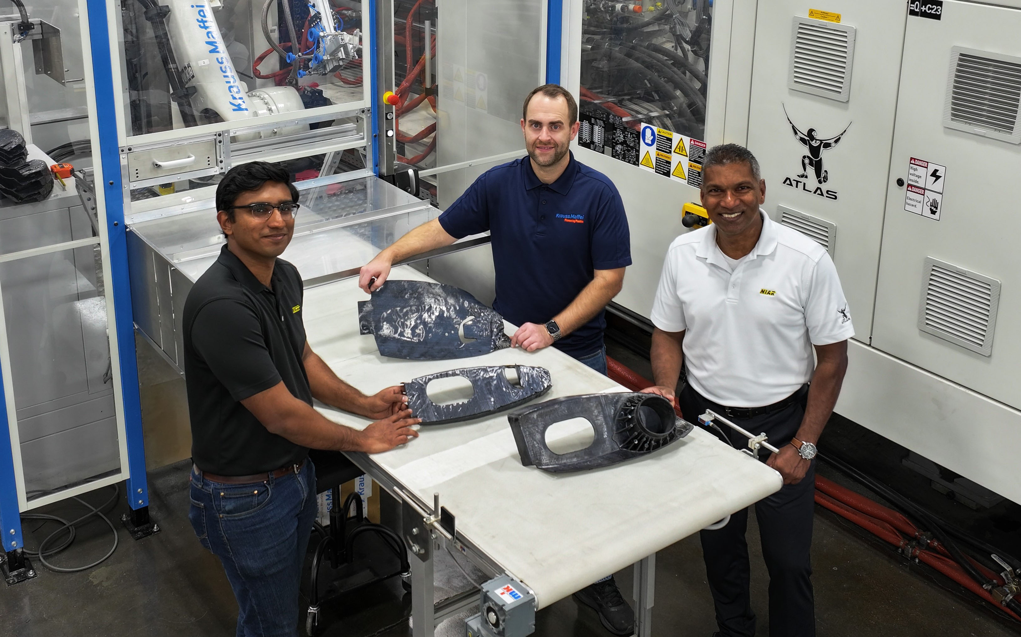 photo of three NIAR employees in the lab posing with overmolding aircraft rib